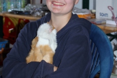 eine strahlende Tomke mit ihrem Lieblingsschweinchen auf dem Arm